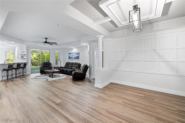 living room featuring decorative columns, ceiling fan, and light hardwood / wood-style floors