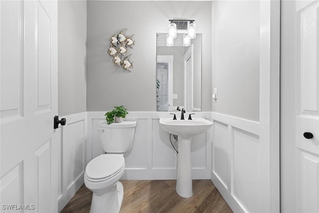 bathroom with hardwood / wood-style floors, toilet, and sink