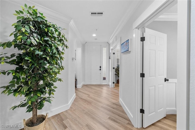 hall with light hardwood / wood-style floors and ornamental molding