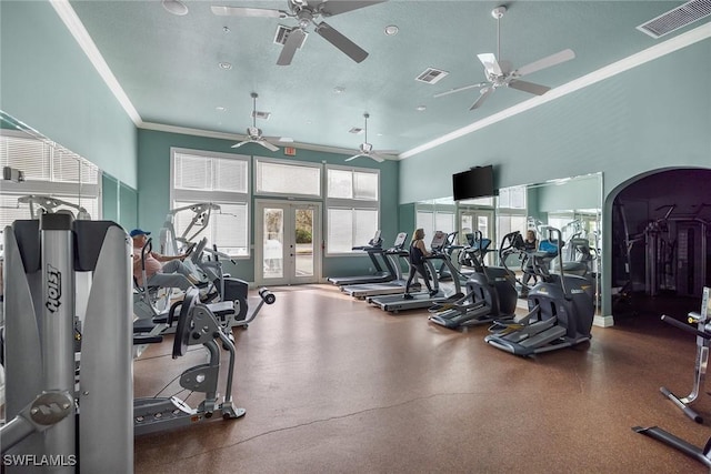 workout area with french doors, a towering ceiling, and ornamental molding