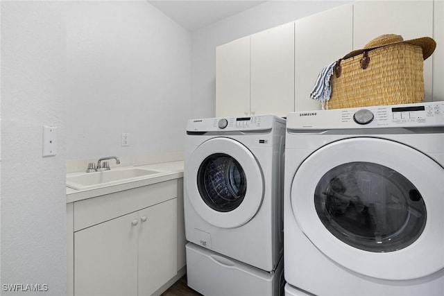 laundry area with cabinets, separate washer and dryer, and sink