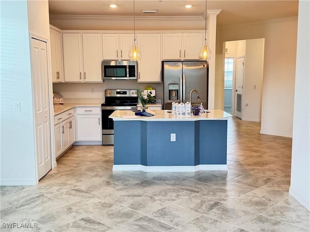 kitchen featuring decorative light fixtures, a center island with sink, white cabinets, and appliances with stainless steel finishes