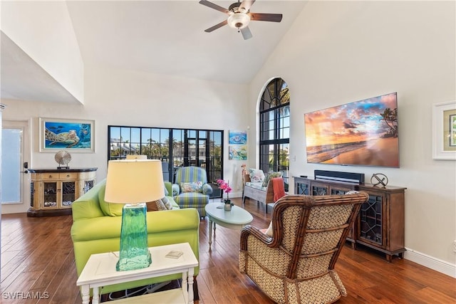 living room with ceiling fan, a healthy amount of sunlight, dark wood-type flooring, and high vaulted ceiling