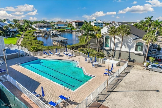 view of swimming pool featuring a patio and a water view