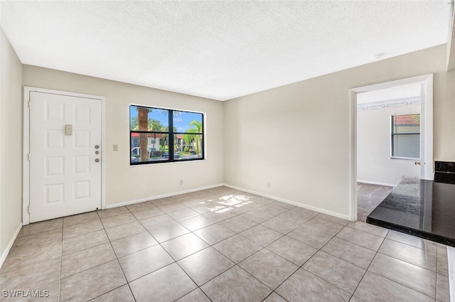 entrance foyer featuring light tile patterned floors and a textured ceiling