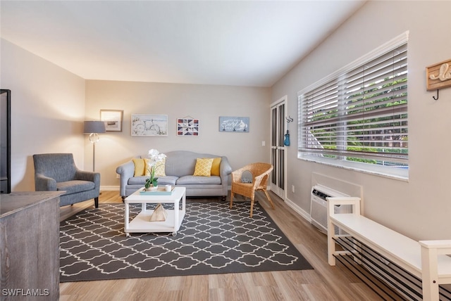 living room with a wall mounted air conditioner and wood-type flooring