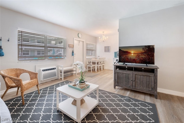 living room featuring hardwood / wood-style flooring, an inviting chandelier, and a wall mounted AC