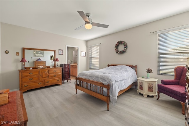 bedroom with multiple windows, ensuite bathroom, ceiling fan, and light hardwood / wood-style floors