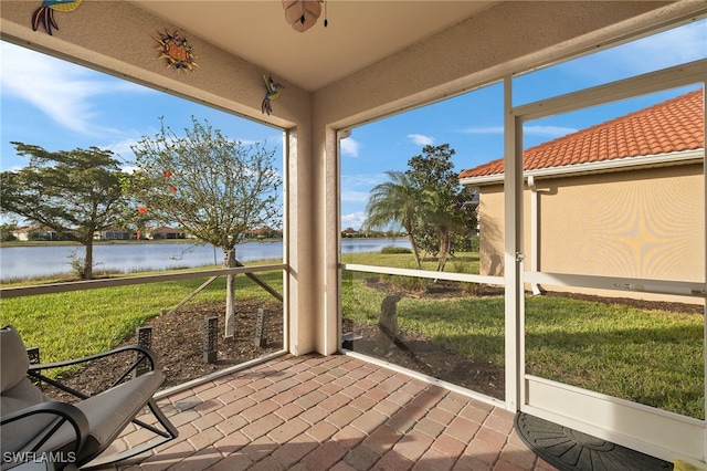 unfurnished sunroom featuring a water view