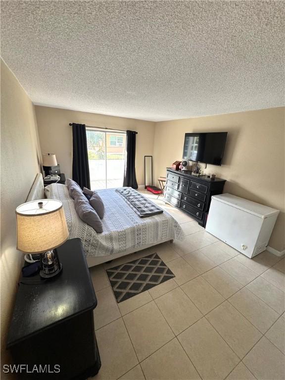 bedroom featuring light tile patterned flooring and a textured ceiling