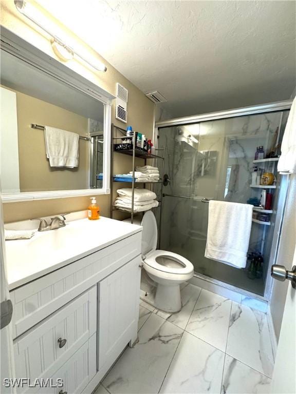 bathroom with a textured ceiling, vanity, toilet, and walk in shower