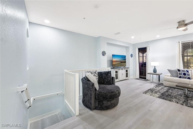 living room featuring ceiling fan and light hardwood / wood-style flooring