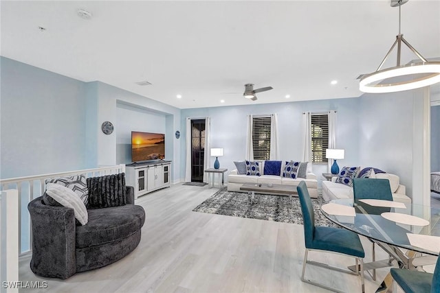 living room featuring ceiling fan and light hardwood / wood-style floors