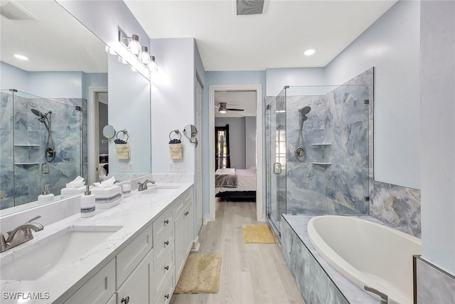 bathroom featuring hardwood / wood-style flooring, vanity, and separate shower and tub