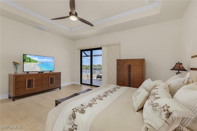 bedroom with ceiling fan, access to exterior, french doors, and a tray ceiling