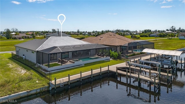 rear view of house with a patio area, a water view, a yard, a lanai, and a swimming pool with hot tub