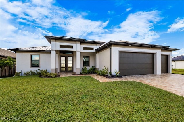 prairie-style home featuring a front lawn, french doors, and a garage