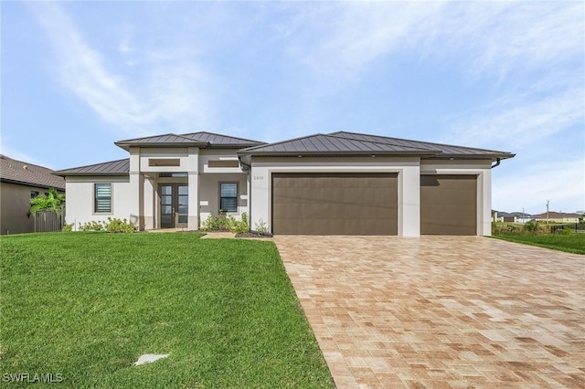 prairie-style home with a front lawn, french doors, and a garage