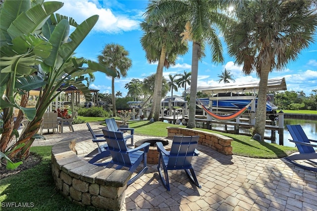 view of patio featuring a water view and a dock