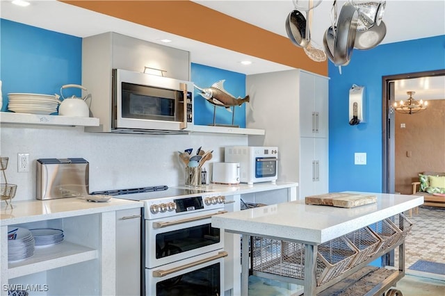 kitchen featuring white appliances, tasteful backsplash, and a notable chandelier