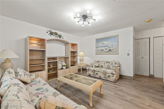 living room with light hardwood / wood-style flooring and a chandelier