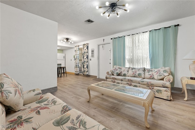 living room featuring light hardwood / wood-style floors and a chandelier