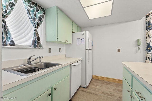 kitchen featuring white dishwasher, light hardwood / wood-style flooring, green cabinetry, and sink