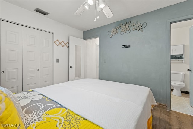 bedroom with hardwood / wood-style floors, connected bathroom, a closet, and ceiling fan