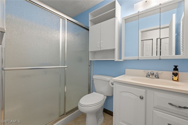 bathroom with tile patterned floors, vanity, toilet, and an enclosed shower