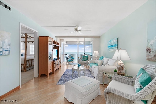 26340 Hickory Blvd Unit 703, Bonita Springs, FL 34134 - living room with a ceiling fan, plenty of natural light, light wood finished floors, and a wall of windows