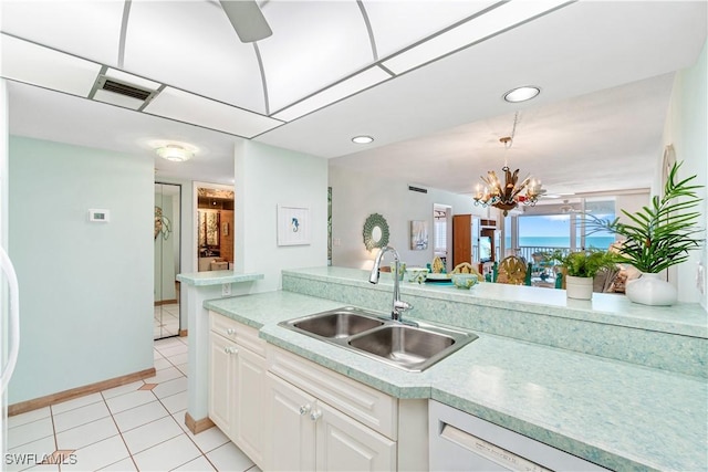 kitchen featuring an inviting chandelier, white cabinets, white dishwasher, sink, and light tile patterned floors