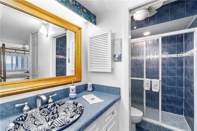 bathroom featuring tiled shower, vanity, and toilet