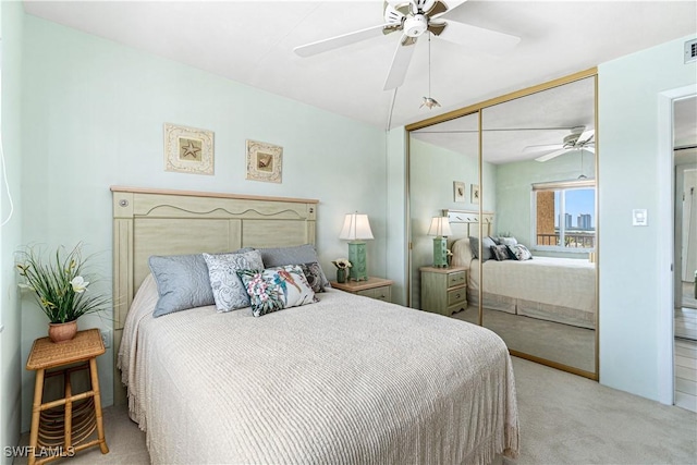 carpeted bedroom with ceiling fan and a closet