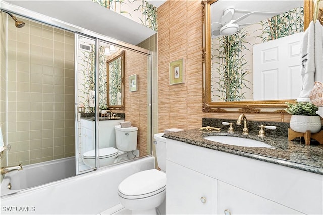 full bathroom featuring shower / bath combination with glass door, vanity, toilet, and ceiling fan