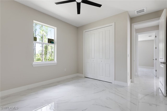 unfurnished bedroom featuring ceiling fan and a closet