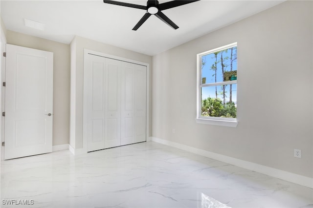 unfurnished bedroom with ceiling fan and a closet