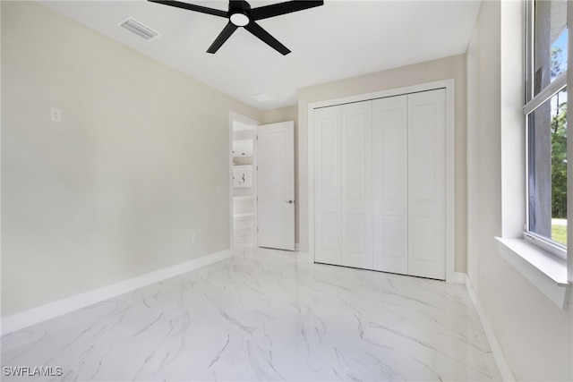 unfurnished bedroom with ceiling fan and a closet