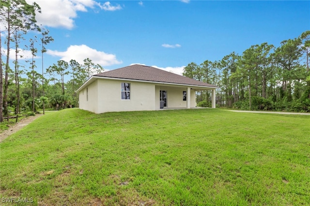 back of property featuring a lawn