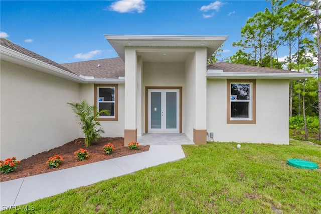 property entrance with a lawn and french doors