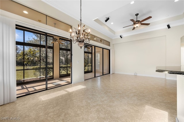 empty room with a raised ceiling, light tile patterned floors, ceiling fan with notable chandelier, and ornamental molding