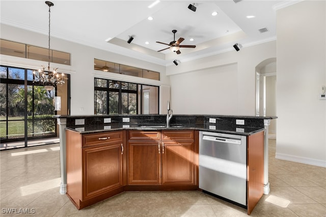 kitchen featuring dishwasher, a raised ceiling, and a kitchen island with sink