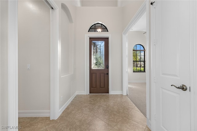 foyer entrance featuring light carpet