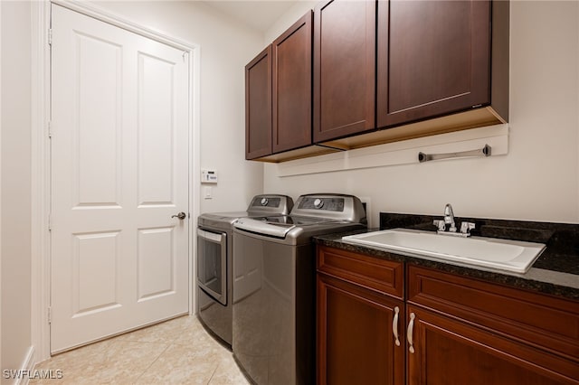 washroom featuring sink, light tile patterned floors, cabinets, and independent washer and dryer