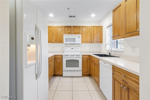 kitchen featuring light tile patterned floors, white appliances, and sink