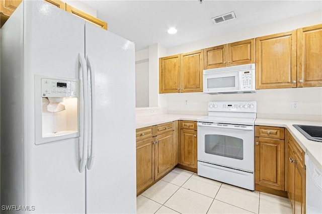 kitchen featuring sink, white appliances, and light tile patterned flooring