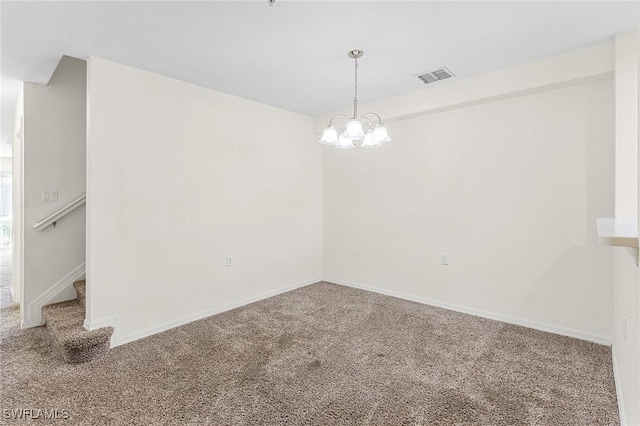 empty room featuring carpet and an inviting chandelier