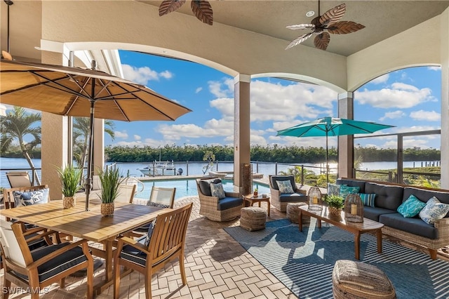 view of patio featuring outdoor lounge area, ceiling fan, and a water view