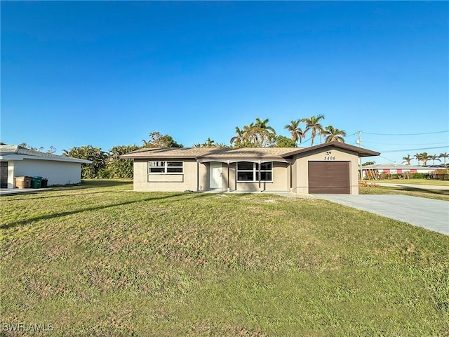 ranch-style house featuring a garage and a front lawn