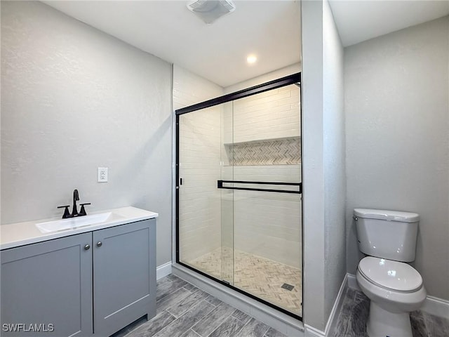 bathroom with vanity, toilet, and an enclosed shower