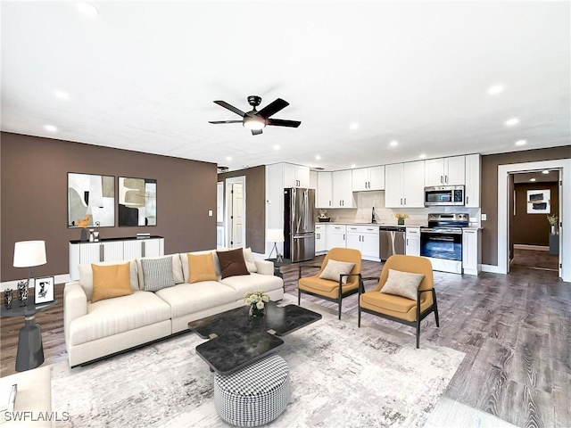 living room featuring ceiling fan, light wood-type flooring, and sink